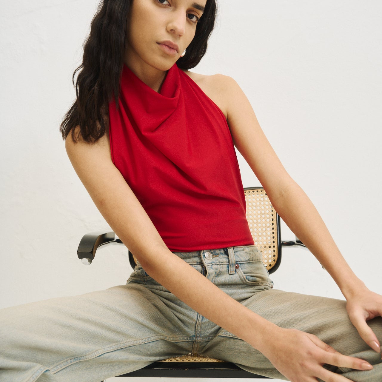 Relaxed girl wearing a sustainable, wellness black one piece made from recycled performace fabric. 